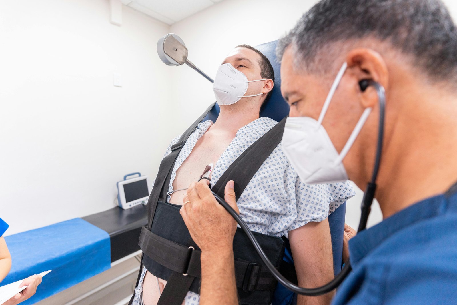 A medical practitioner conducts a chest examination on a patient using a stethoscope in a clinical setting.